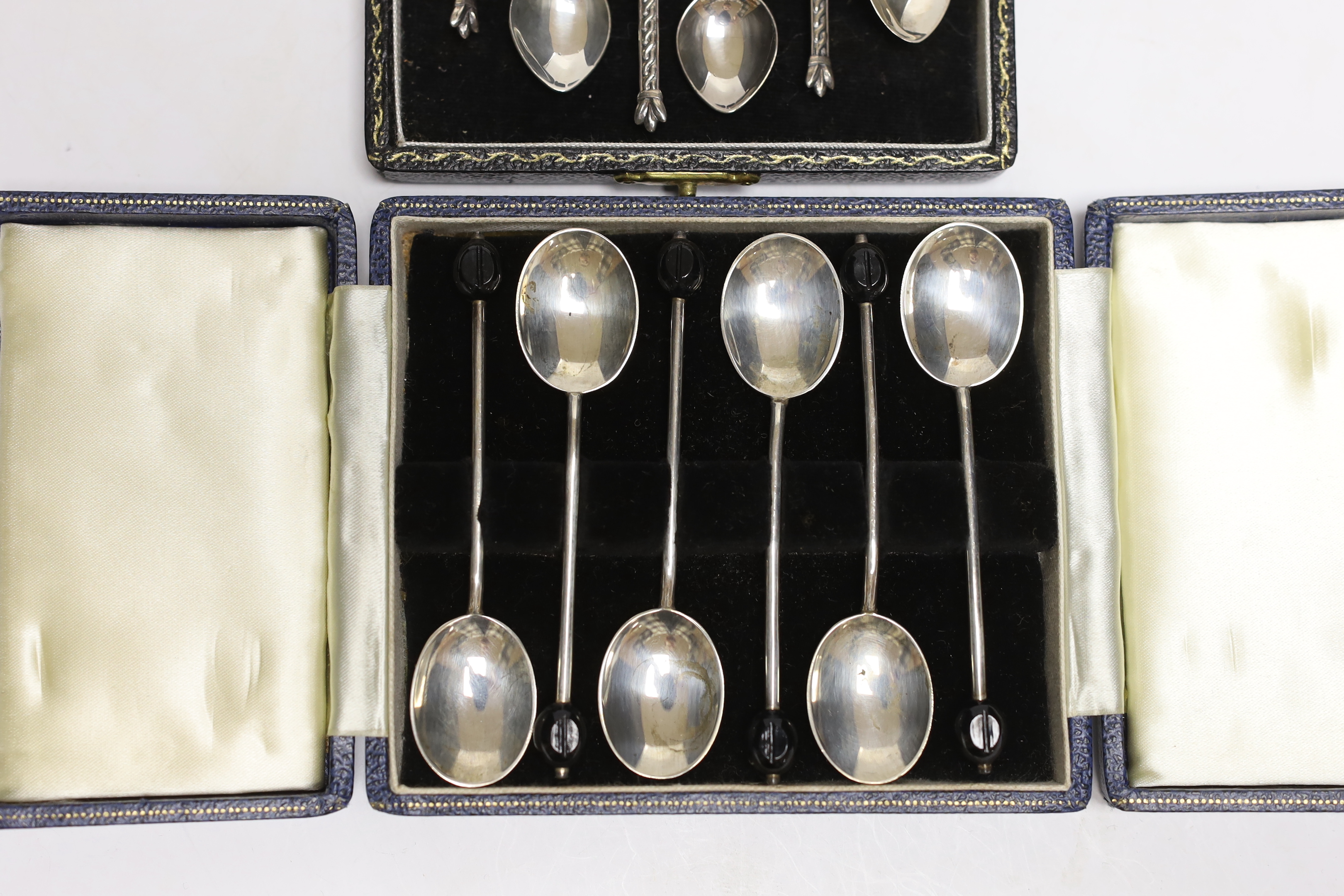 Two cased sets of six Elizabeth II silver coffee spoons, including bean end and Celtic style.